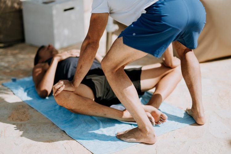 Estiramientos de los aductores en deporte con ayuda