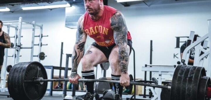 Los halteras o weightlifters levantan barra con discos de peso