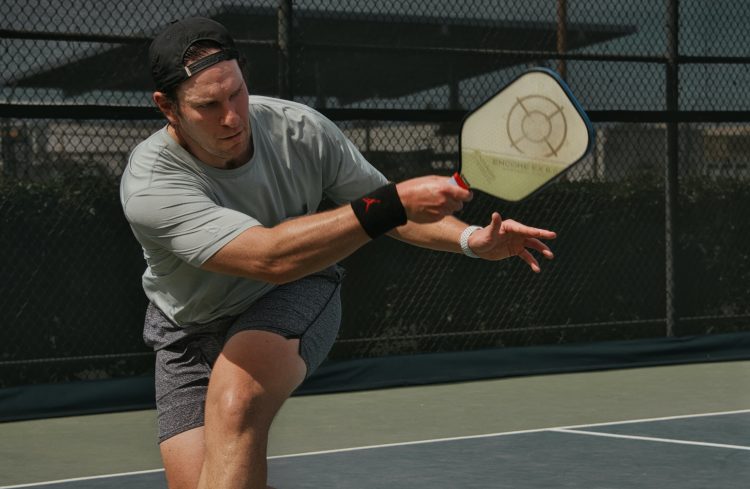 Jugador de pickleball, la pala, la pelota y la pista