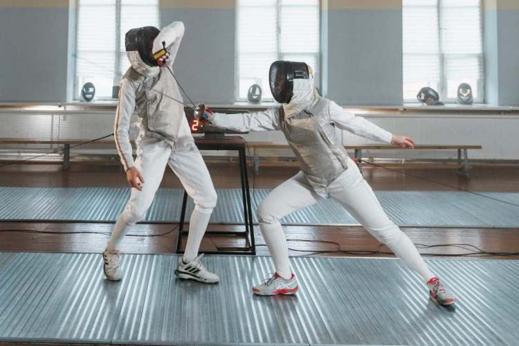 Esgrimistas practicando esgrima con florete, espada o sable